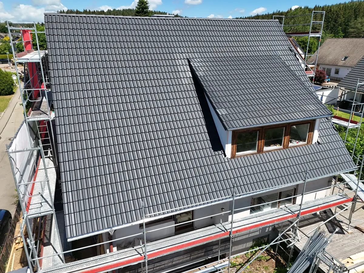 Fertige Neueindeckung aus der Luft — Wohnhaus mit Gauben und neuem Kaminkopf