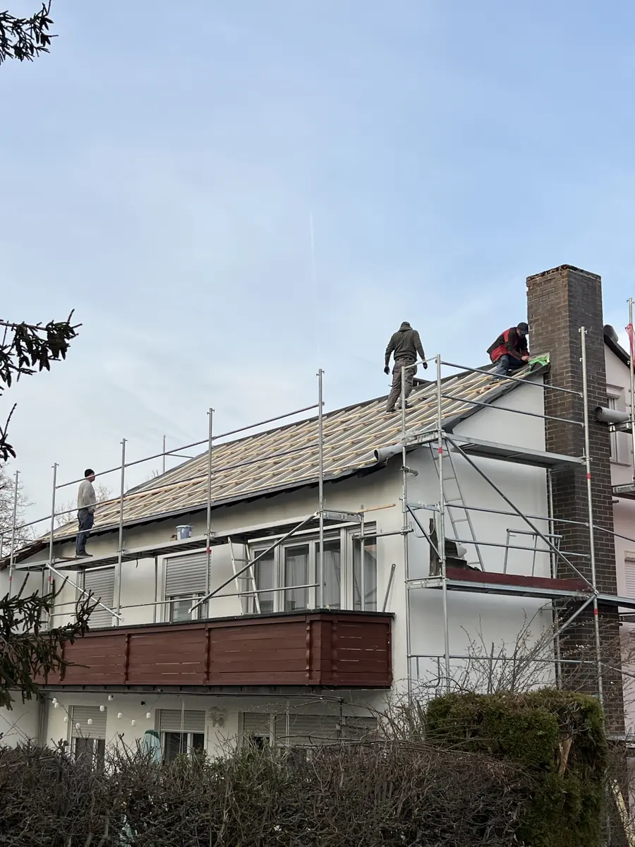Handwerker tragen die alte Dacheindeckung ab