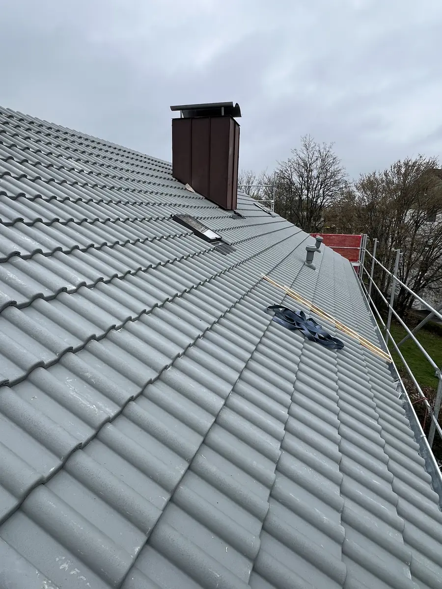 Handwerker montieren den First auf dem neuen Dach