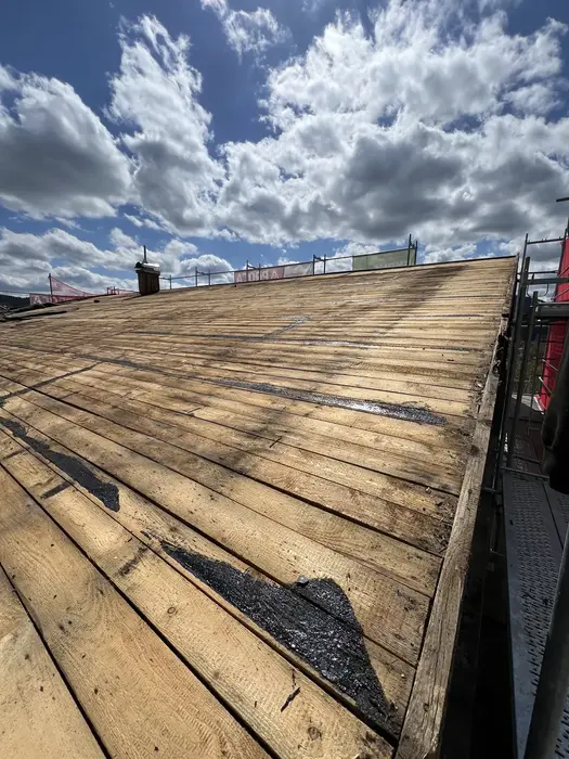 Abgedecktes Dach mit freigelegter alter Holzschalung