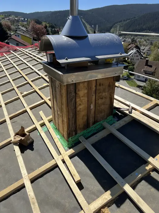 Neu aufgebauter Kaminkopf mit Abdeckhaube auf der Lattung