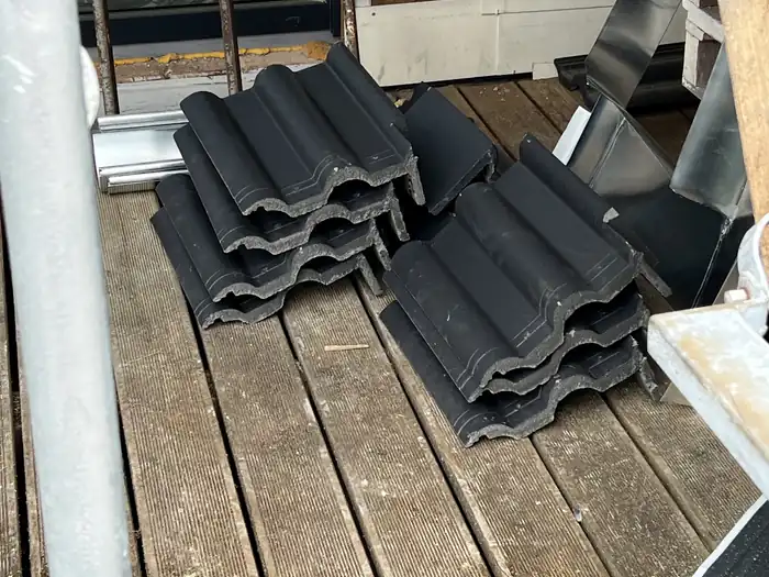 Stapel neuer Dachsteine auf dem Gerüstgang bereitgelegt