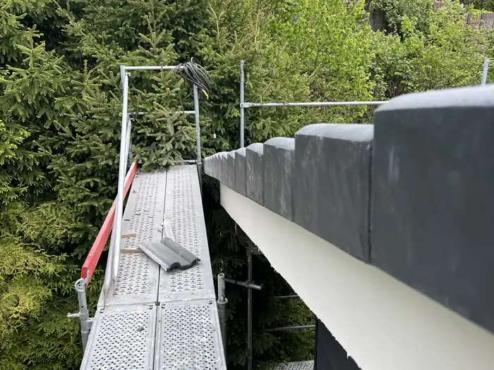 Gerüstgang entlang des dunklen Firstabschlusses