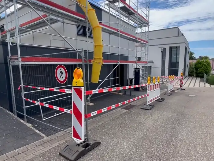 Eingerüstetes Mehrfamilienhaus mit Betonpumpe