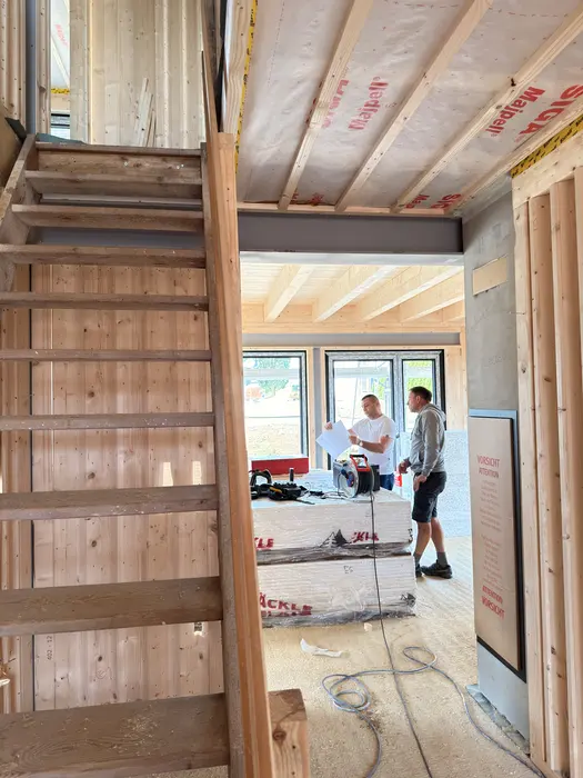 Dachgeschossausbau mit Holzkonstruktion, Treppe und zwei Handwerkern