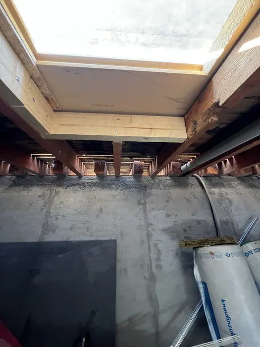 Balkenlage mit Dämmebene und Folie unter der Betondecke