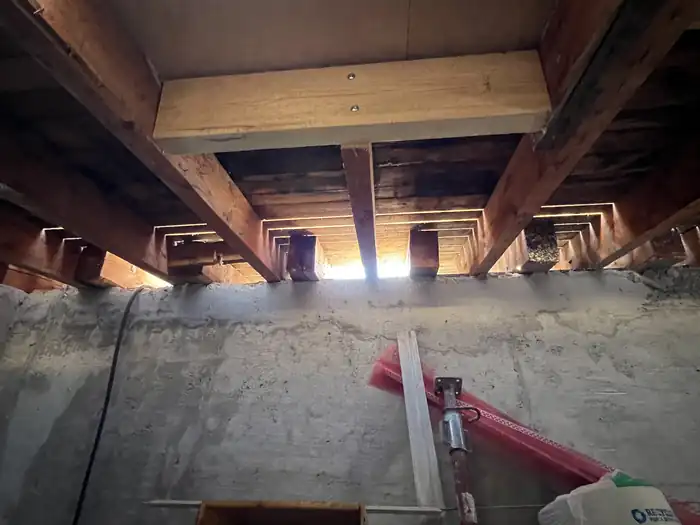 Balkenlage und Betondecke von unten im Kellergeschoss